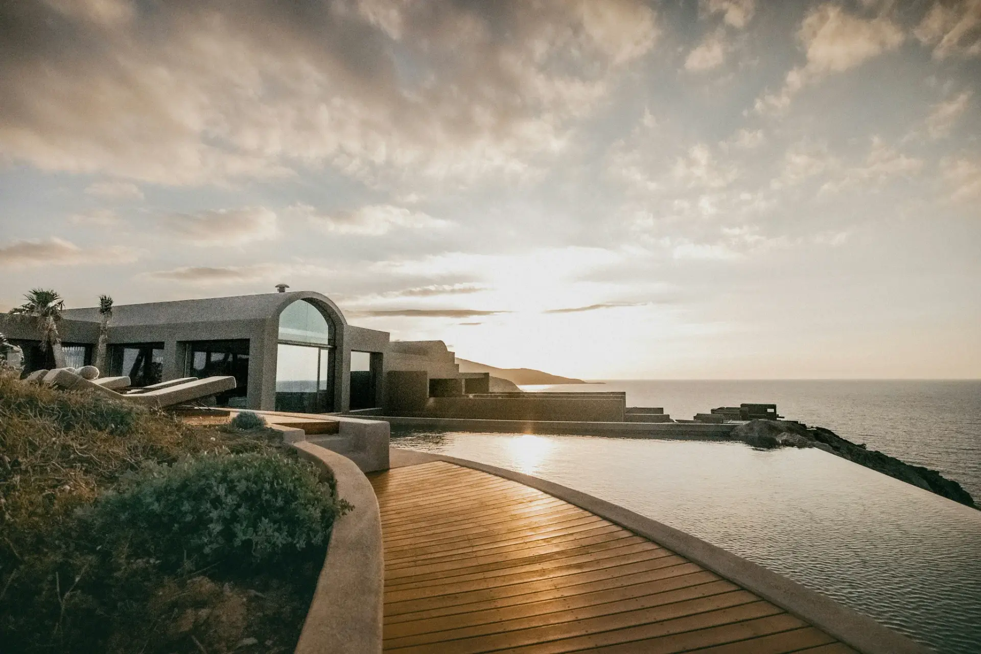 a wooden walkway leading to a building on a beach