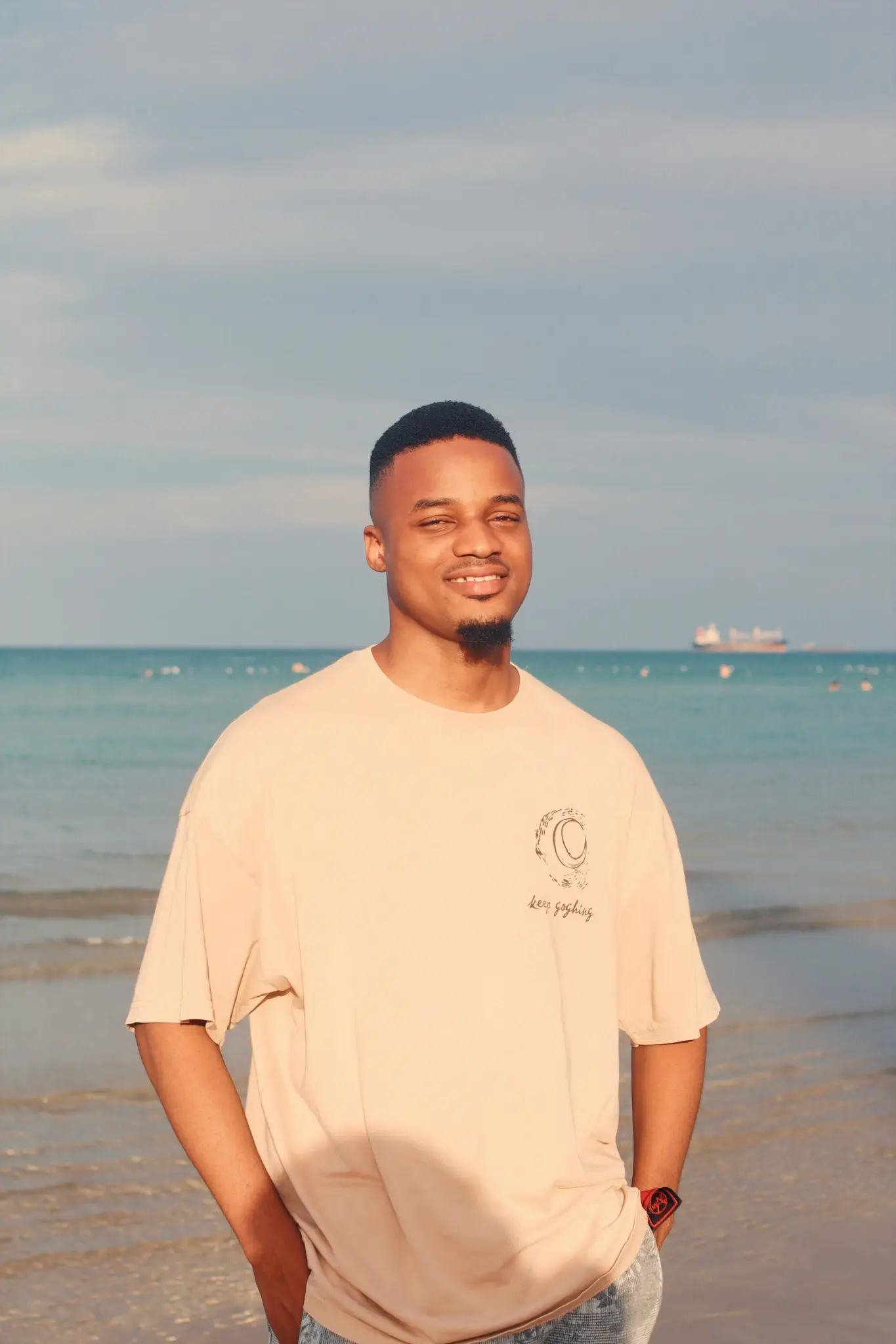 Young man smiling at the beach with ocean in background
