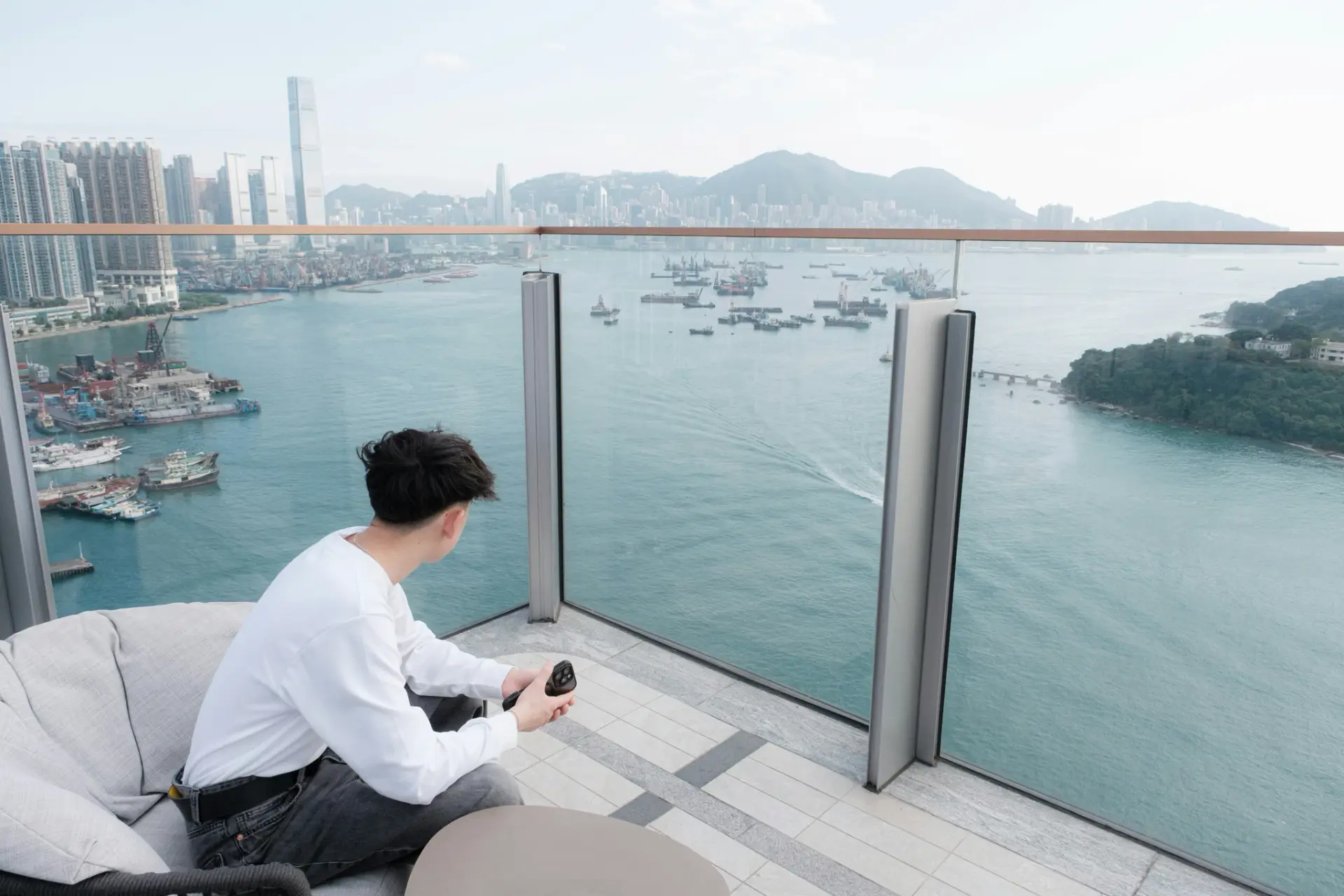 Man on balcony overlooks city and harbor